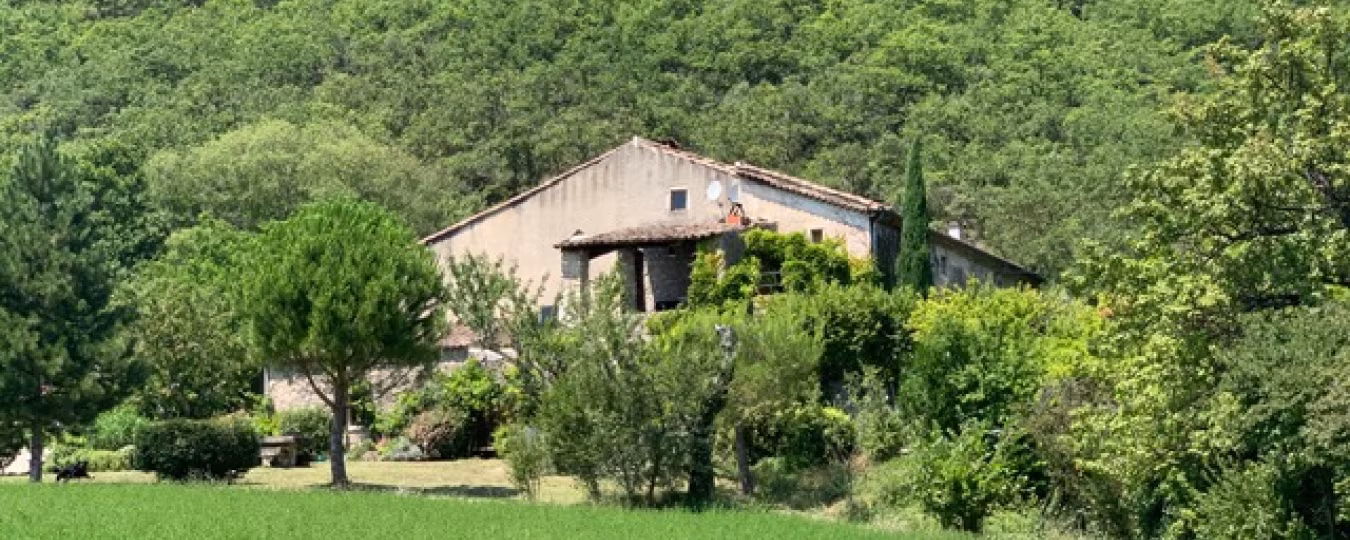 Landschap met traditioneel huis bij le mas d'aunas, landelijke rust in zuid-ardèche met bomen en grasveld