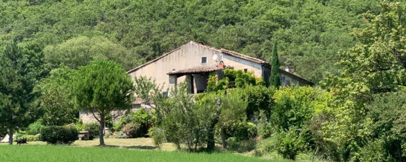 Landschap met traditioneel huis bij le mas d'aunas, landelijke rust in zuid-ardèche met bomen en grasveld