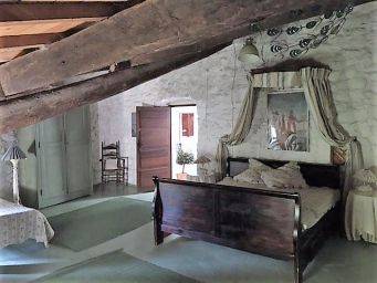 Sfeervolle slaapkamer zolderkamer met houten balken en tweepersoonsbed landelijke landelijke woning rust